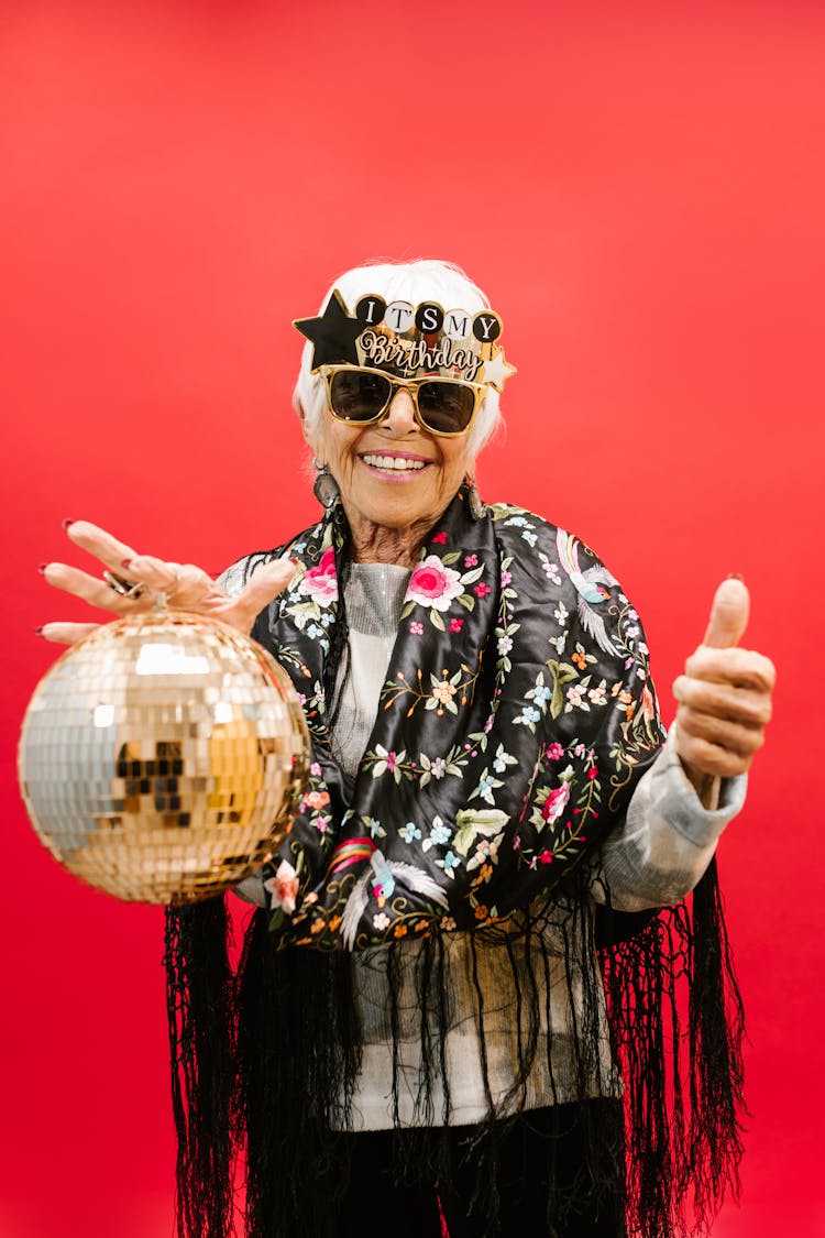 Elderly Birthday Celebrant Holding A Disco Ball 