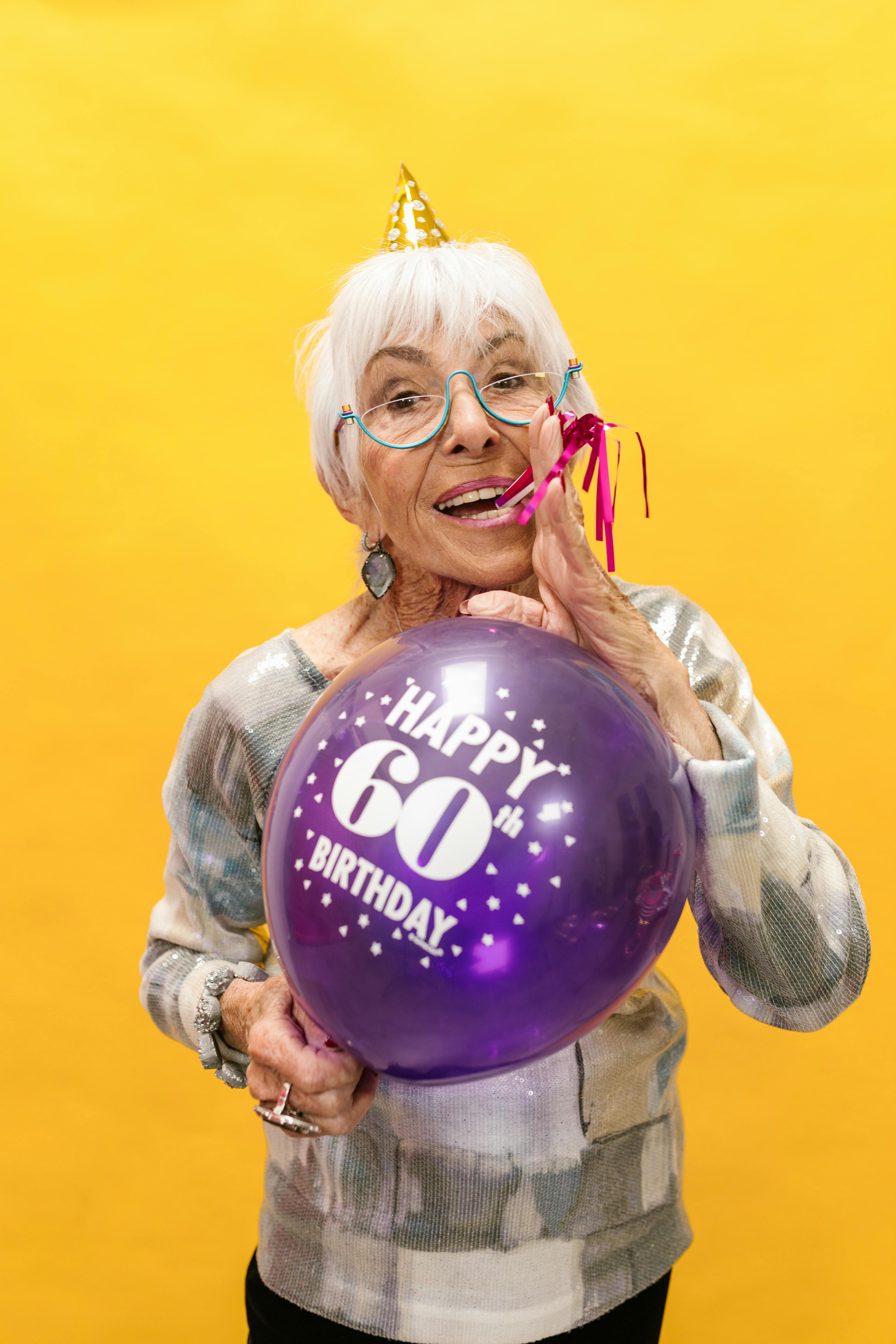 elderly woman holding a purple balloon