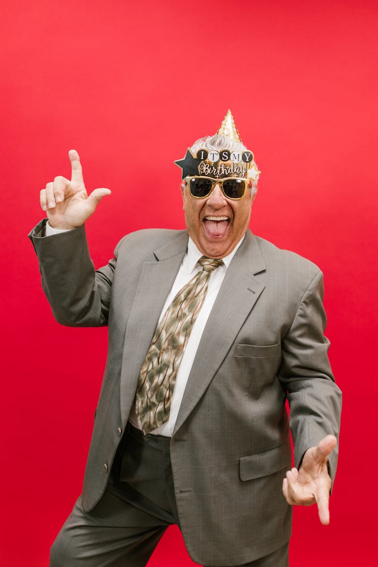 A Man In Gray Suit Jacket Wearing Sunglasses