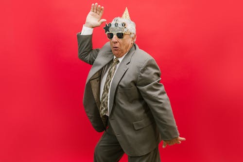 A Cheerful Elderly Man in Gray Suit Celebrating His Birthday