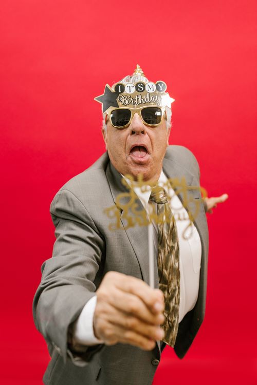 Free Elderly man in suit celebrating birthday with festive glasses, exuding joy and excitement. Stock Photo