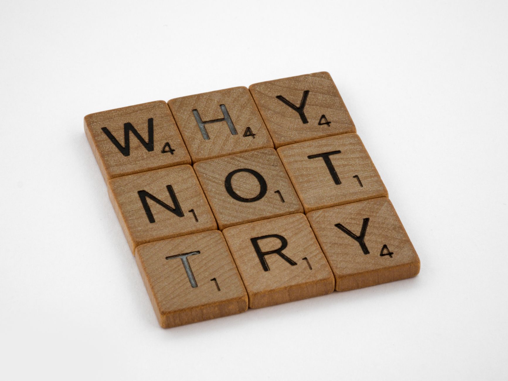 Brown Wooden Letter Tiles on White Surface