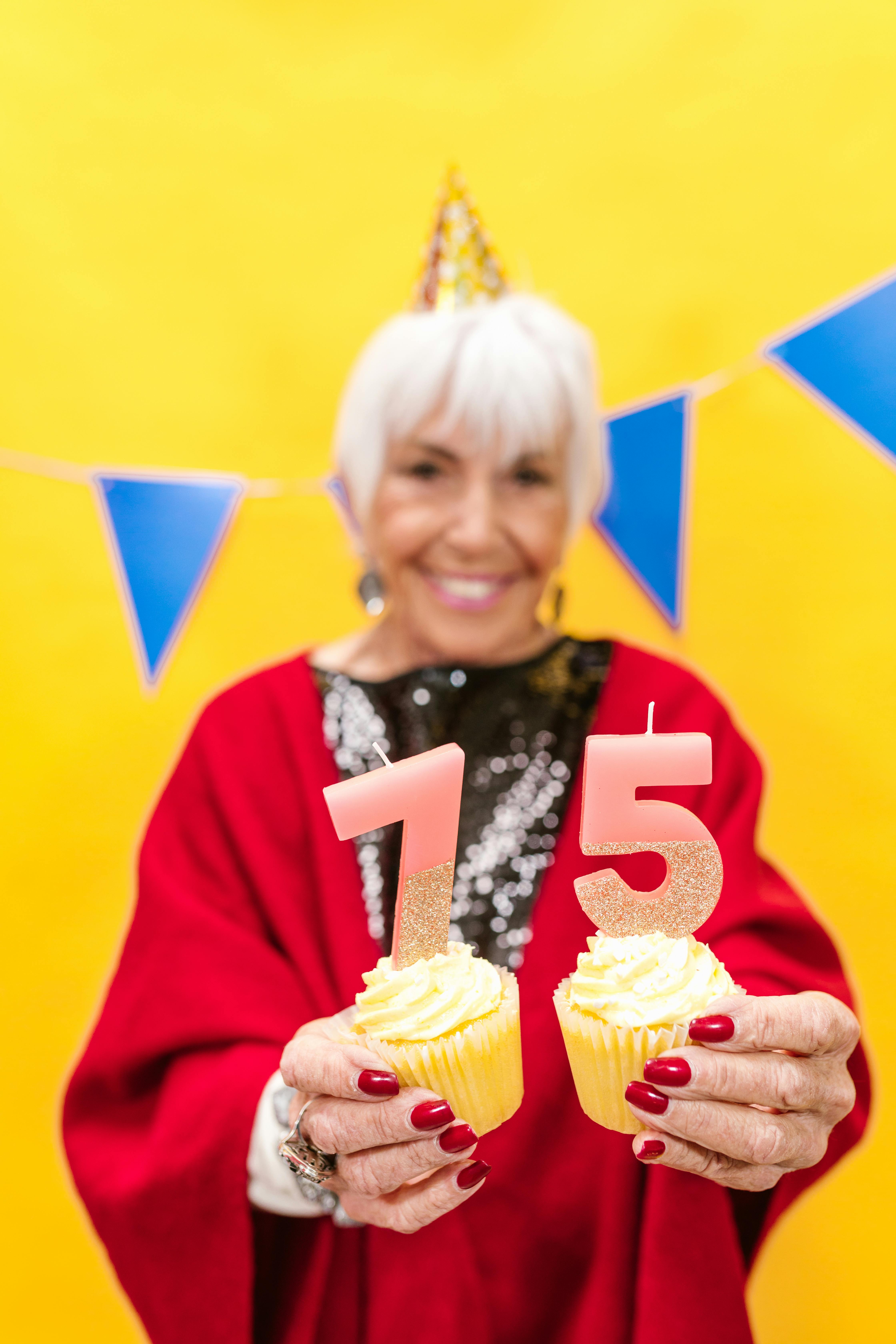 an elderly woman holding cupcakes