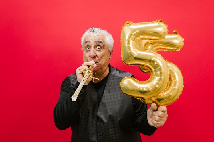 A Man Blowing A Party Horn