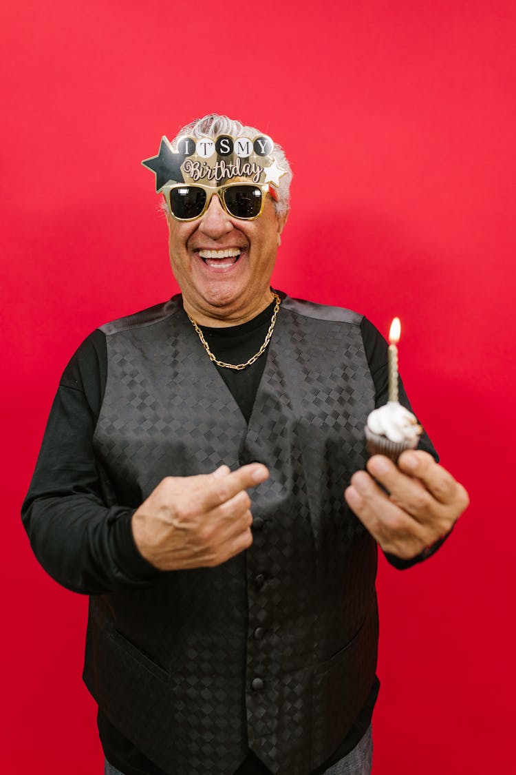 Man Wearing Sunglasses Pointing Cupcake On His Hand 