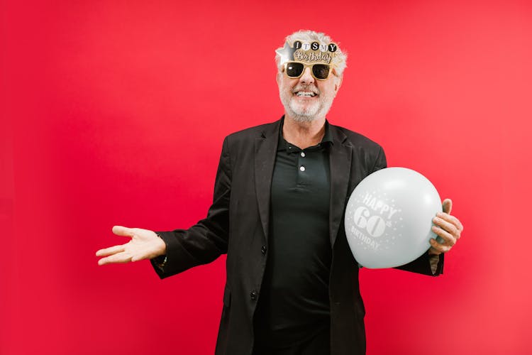 Man In Black Suit Jacket Holding A Balloon