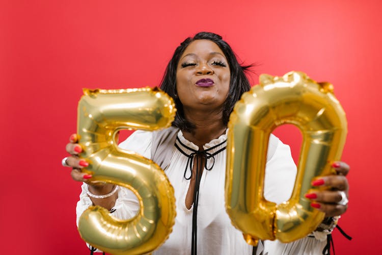 A Woman Holding Gold Balloons