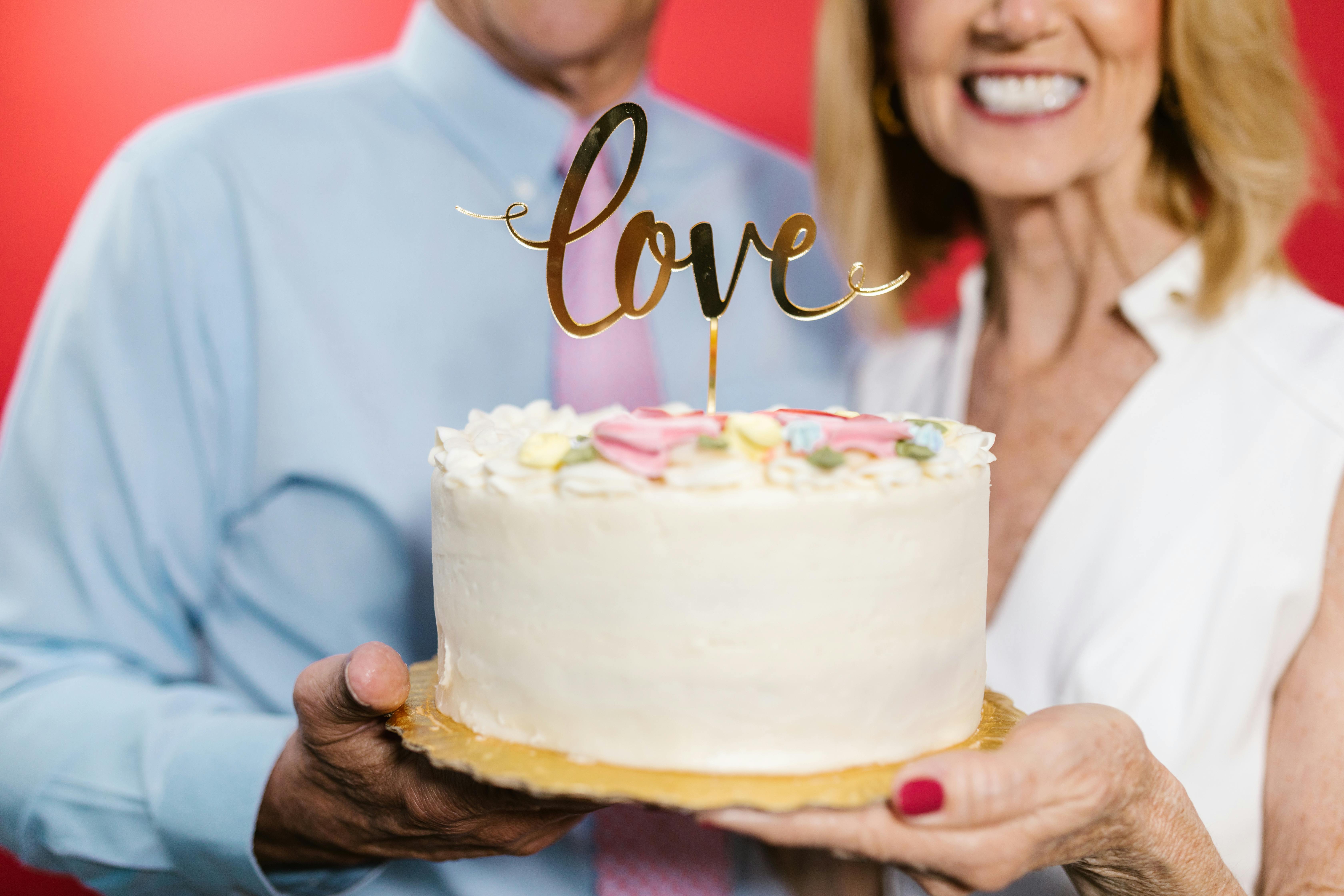 woman in white dress shirt holding white cake