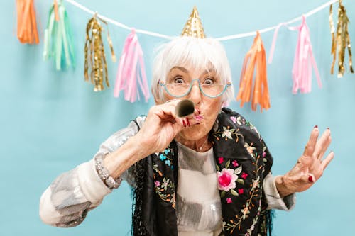 Free Elderly Woman Blowing a Party Horn Stock Photo