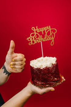A vibrant red background highlights a joyful birthday cake with a thumbs-up gesture.