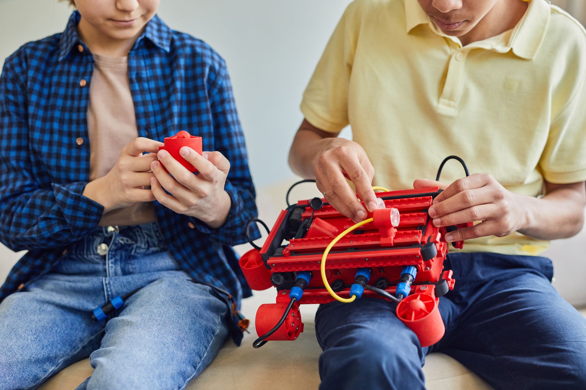 Two children assembling a robot, fostering teamwork and STEM learning.