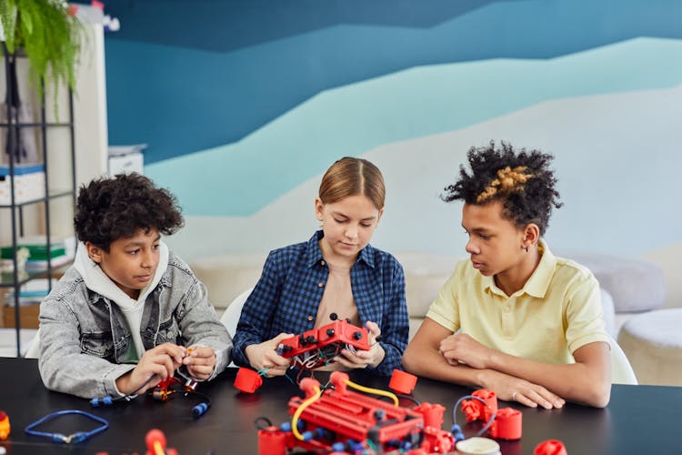 Children Sitting, Playing And Learning Electronics