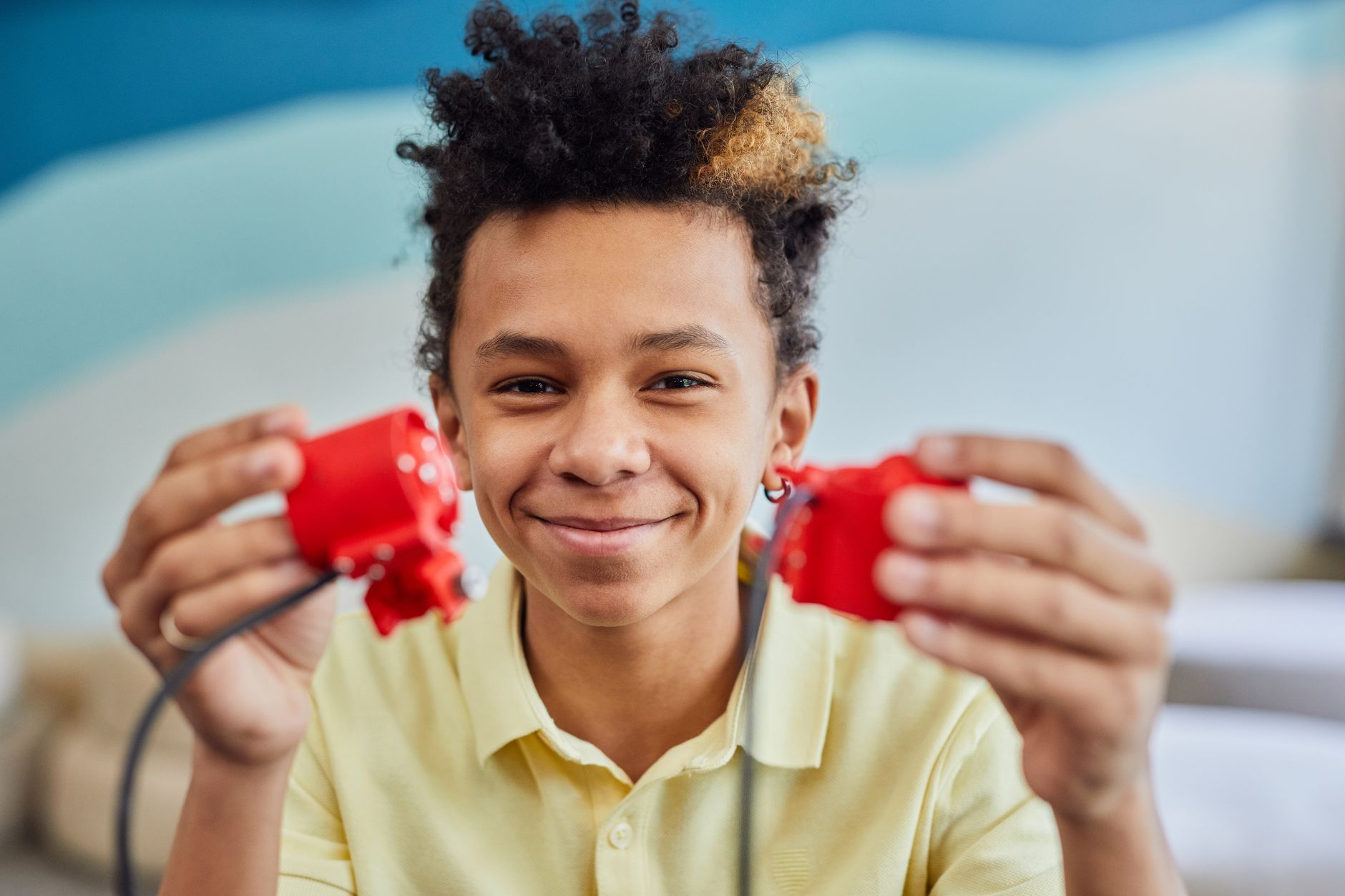 A cheerful teen with a robotics kit, capturing a moment of creativity and technology indoors.