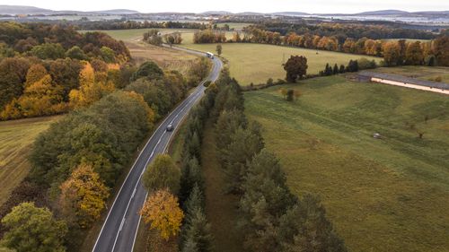 Free Enjoy a stunning drone view of a winding road through the colorful autumn landscape in Hungary. Stock Photo