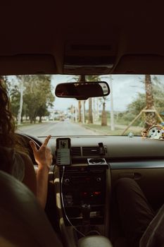 Interior car view with people driving through scenic Faro, Portugal.