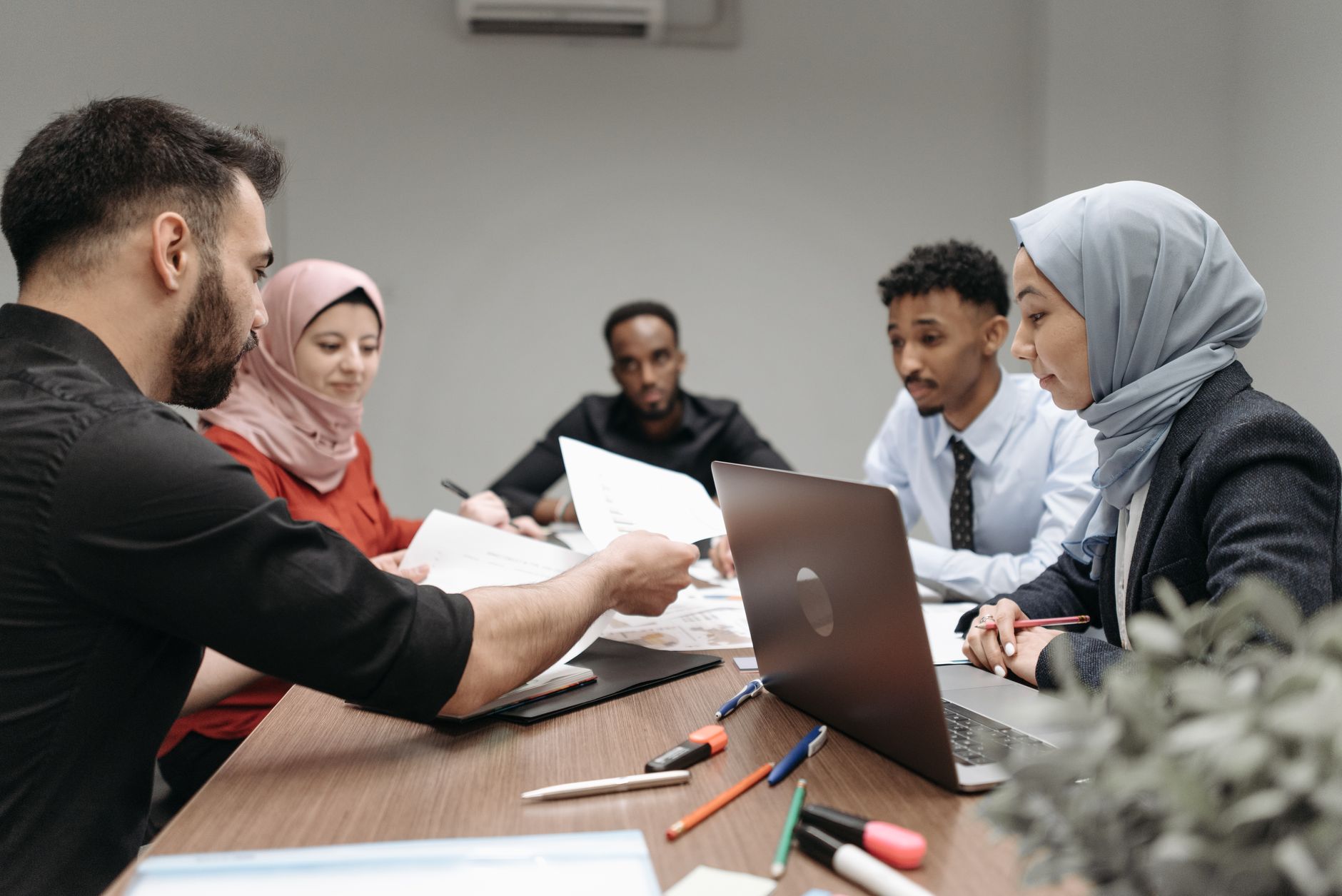 A diverse team collaborating in an office meeting, relevant to multilingual communication.