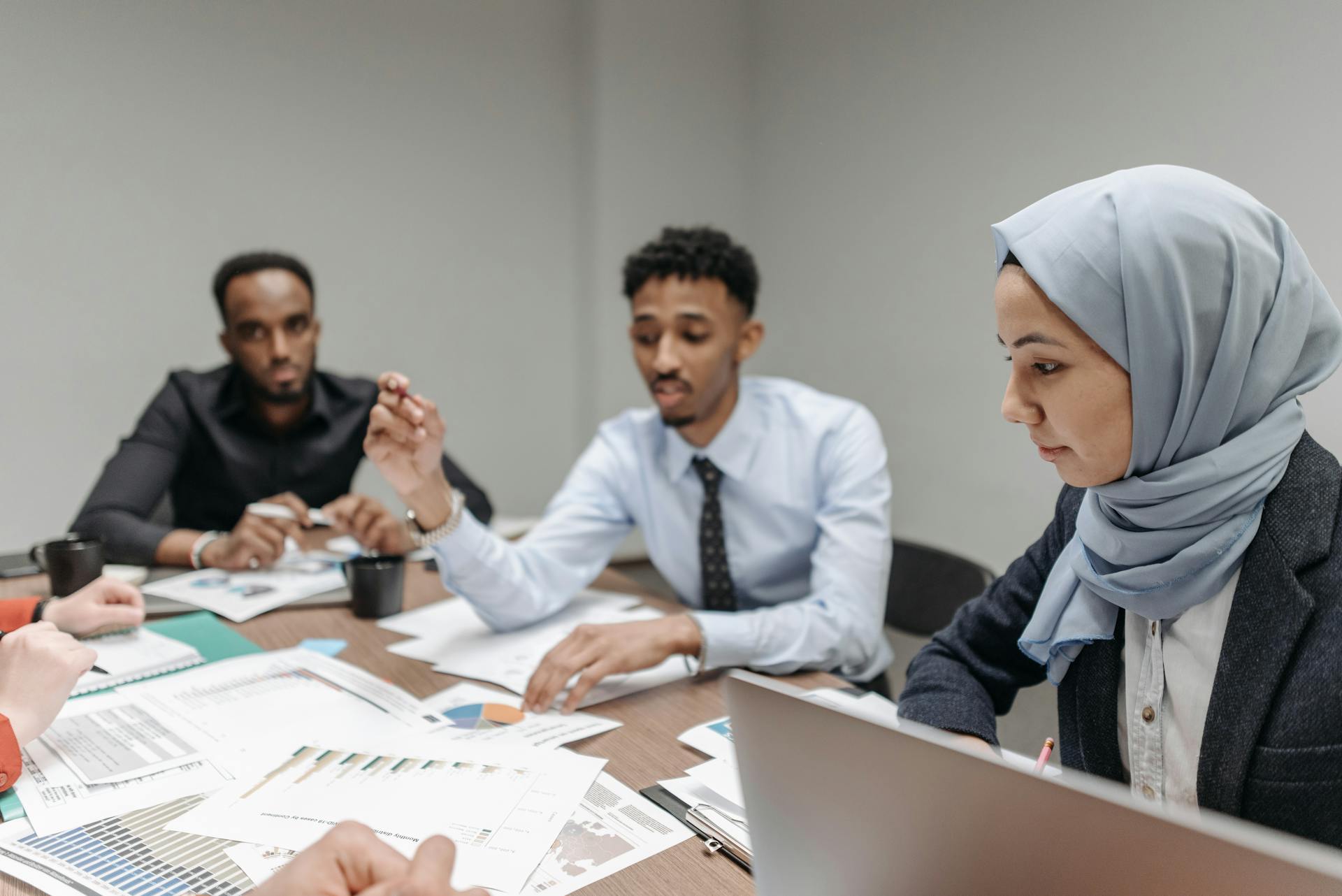 A multicultural team engaged in a productive office meeting, discussing business strategies.