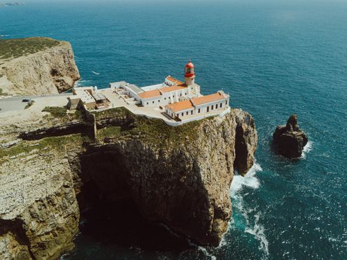 Free Dramatic aerial view of Cabo de São Vicente Lighthouse on cliffs in Portugal. Stock Photo