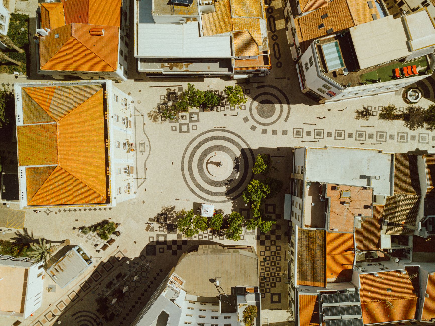 Drone shot of Lagos, Portugal cityscape showcasing intricate courtyard patterns and rooftops.