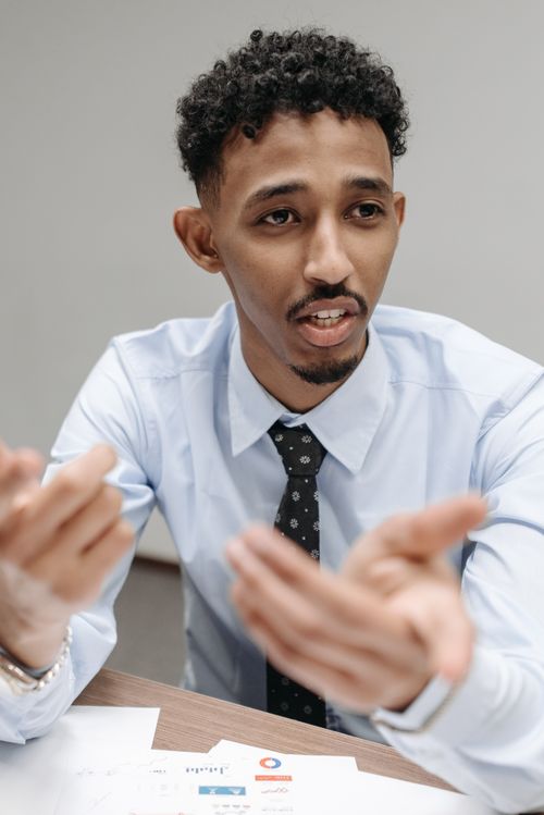 Free Young professional man actively engaged in a thoughtful office discussion. Stock Photo