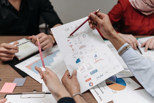 Team analyzing business reports and charts during a collaborative meeting.