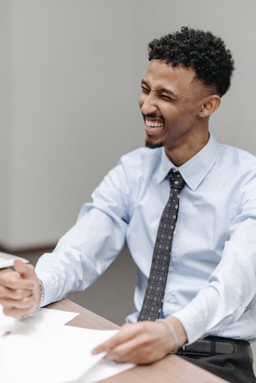 Free A Man Sitting at the Table while Laughing  Stock Photo