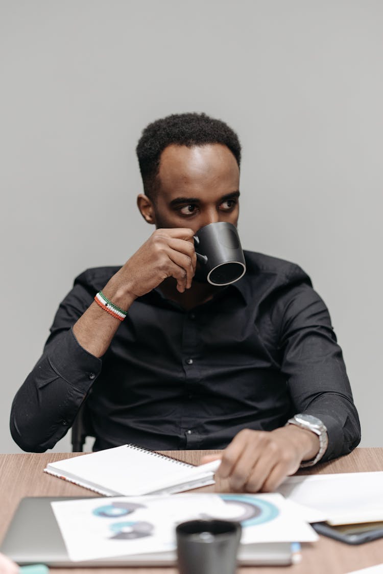 A Man Drinking Coffee In The Office