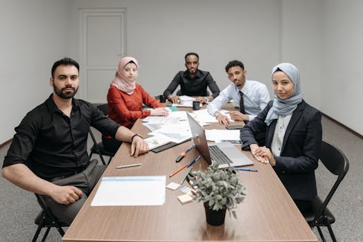 A diverse group of professionals engaging in a business meeting in a modern office setting.