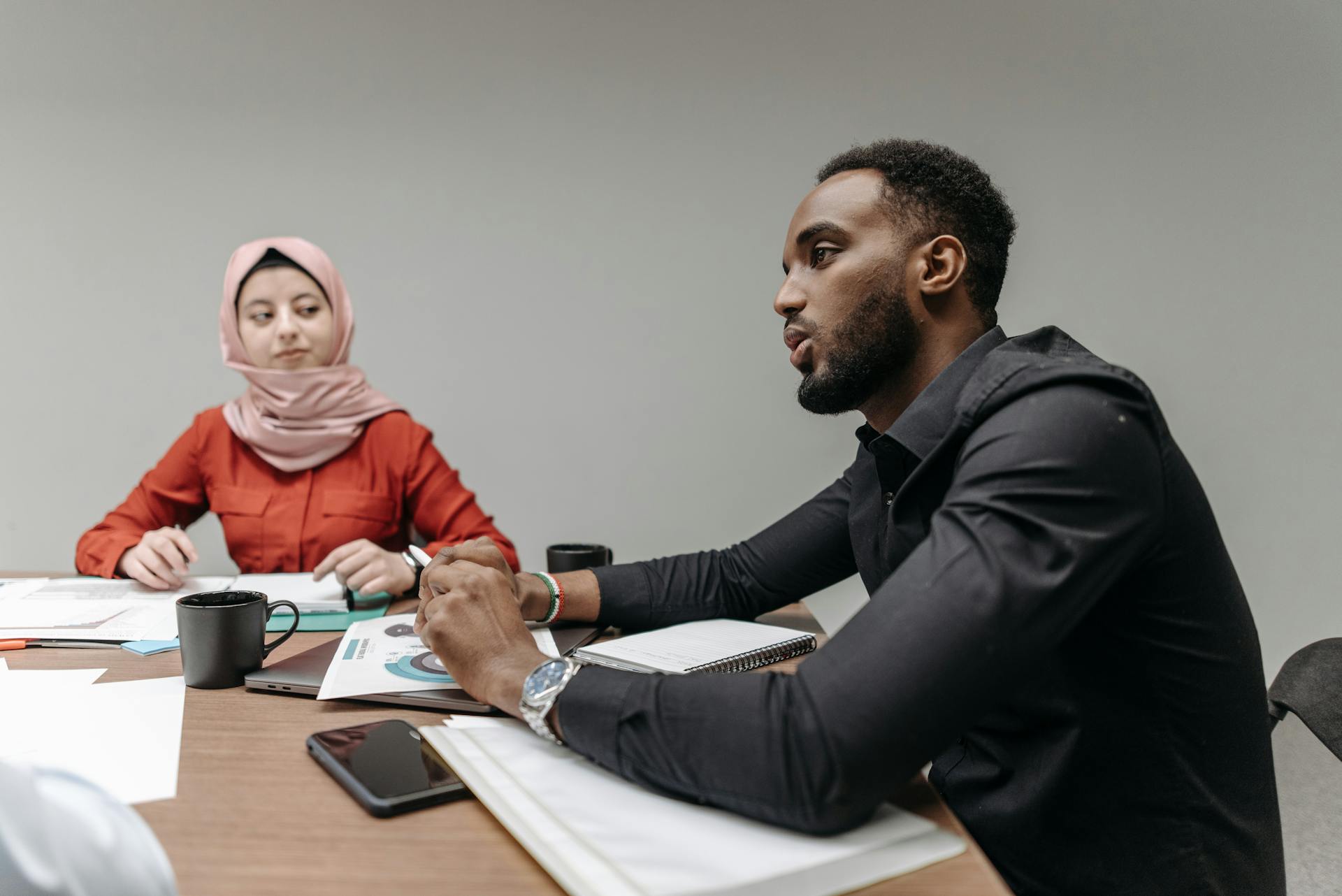 Business meeting with diverse team members discussing strategy and ideas at an office table.