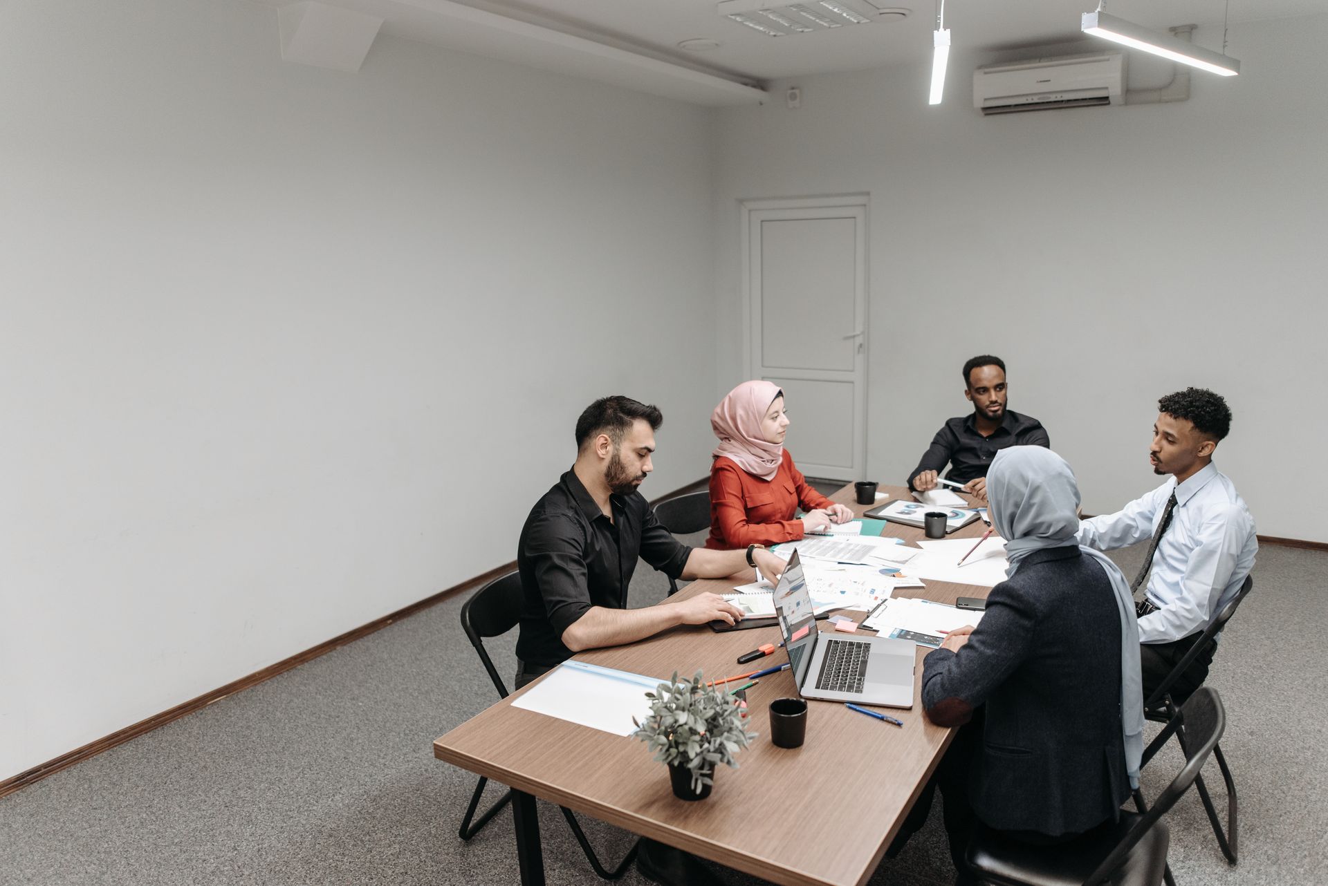 A diverse group of professionals engaged in a business meeting around a conference table.