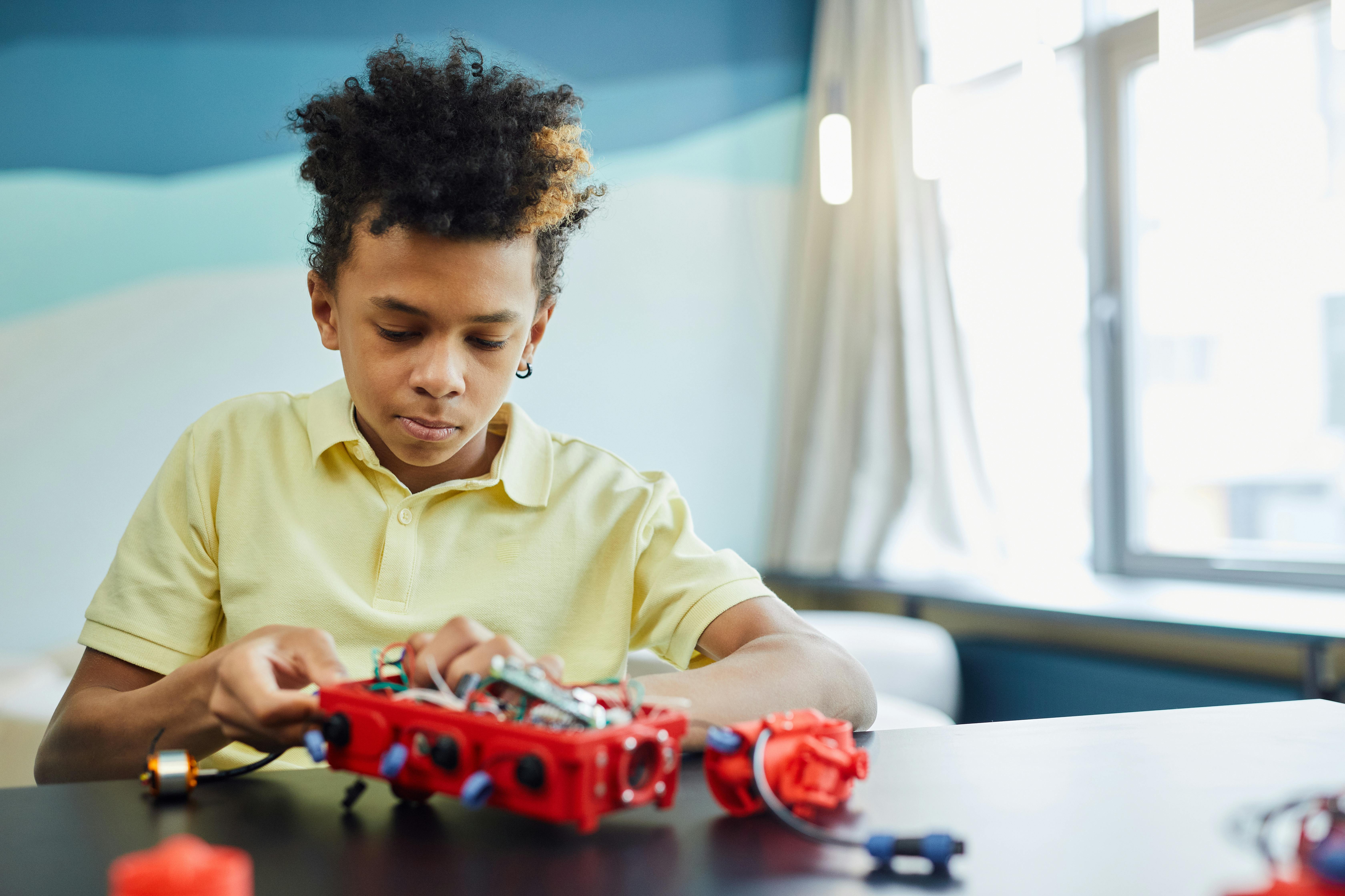 a boy fixing his robotic project