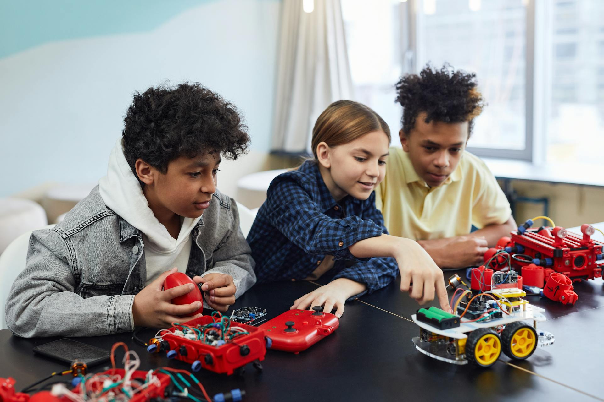 Diverse kids collaborating on robotics project, promoting STEM learning in a creative environment.