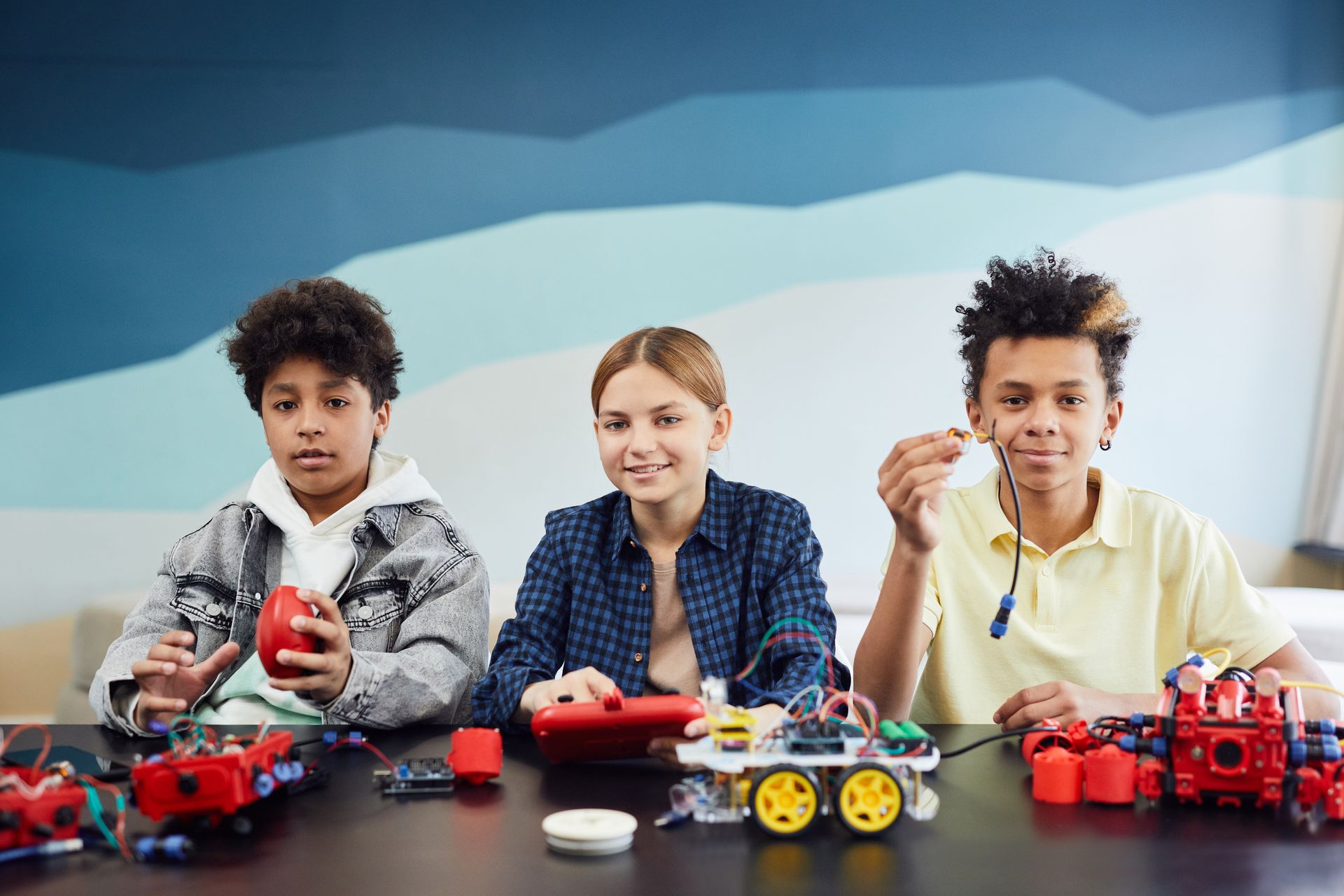 Kids Sitting Near a Table with Battery Operated Toys
