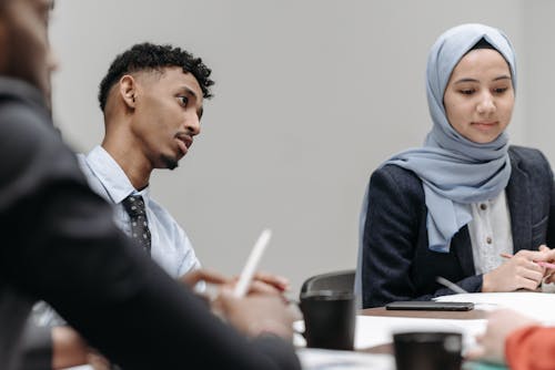 Man with Black Necktie Sitting Beside Woman Wearing Hijab