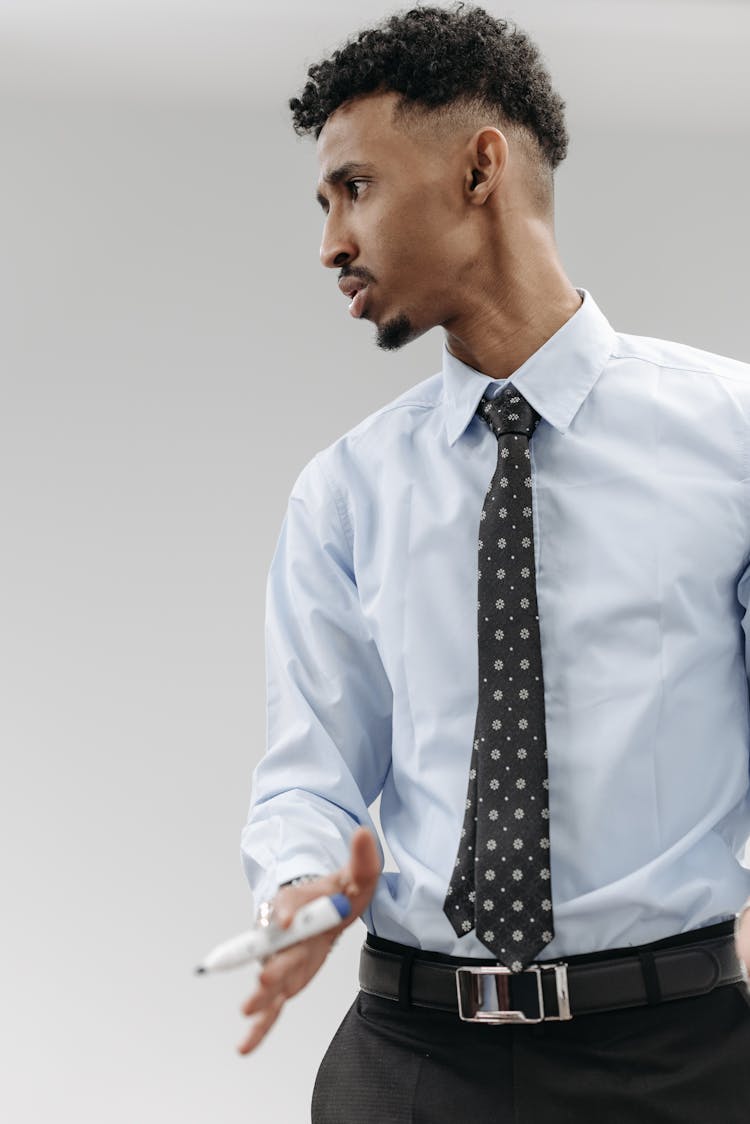 A Man In Long Sleeves And Necktie Holding A Blue Marker