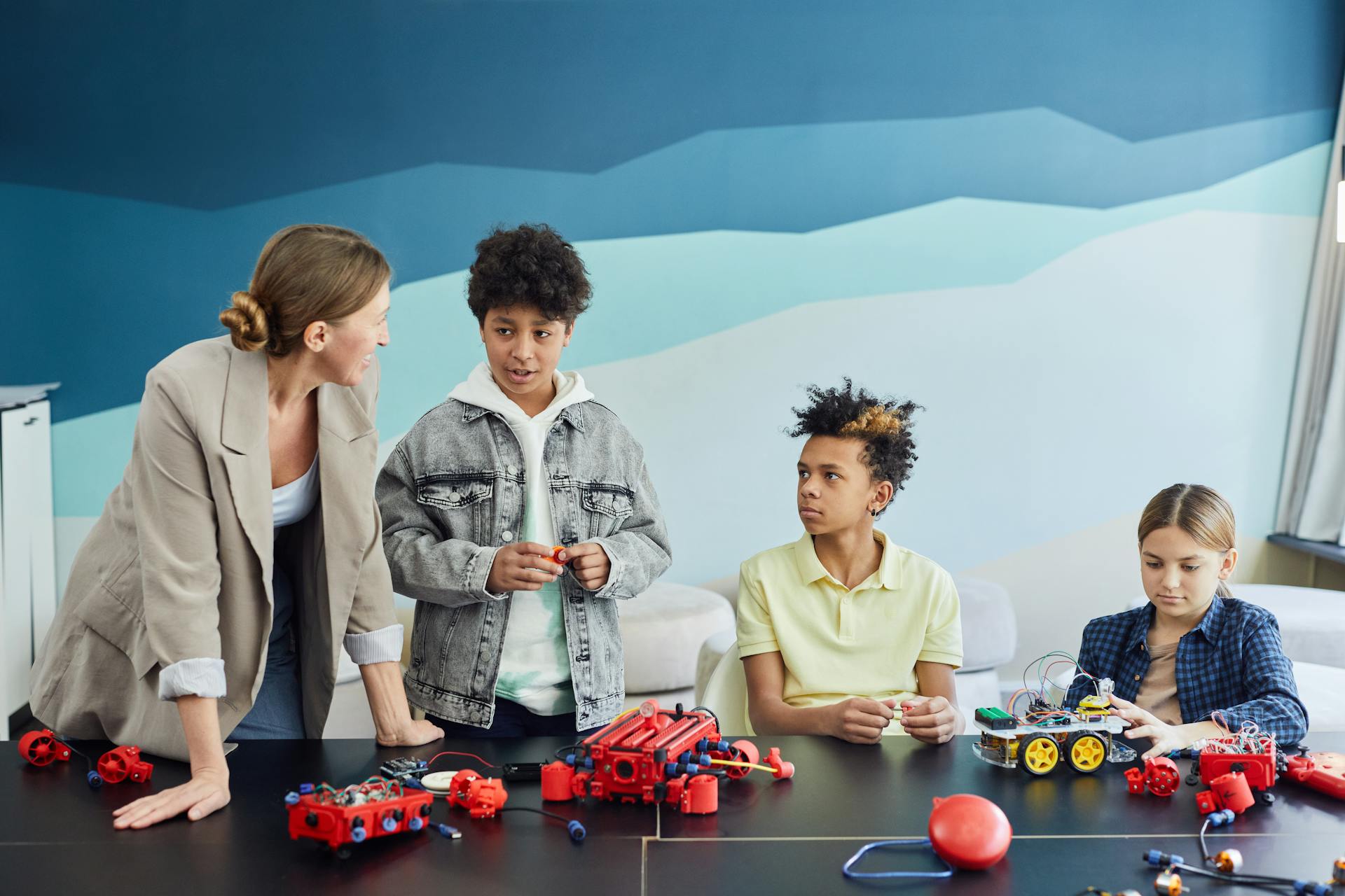 Students and teacher collaborate on robotics at school. Learning and innovation in education.