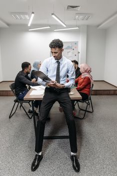 Office worker holding a clipboard during a meeting, capturing a diverse team collaborating.