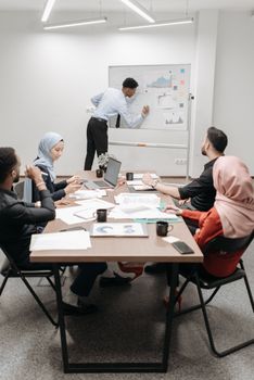 An office team of mixed ethnicities collaborating in a modern meeting room.
