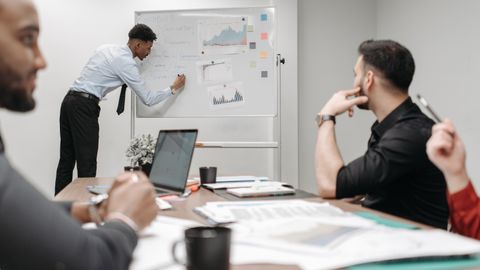 Colleagues in a business meeting discussing data and strategies at the office.