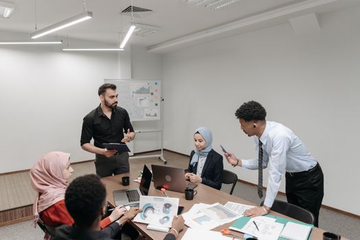 A diverse group of professionals engaged in a team meeting in a modern office setting.