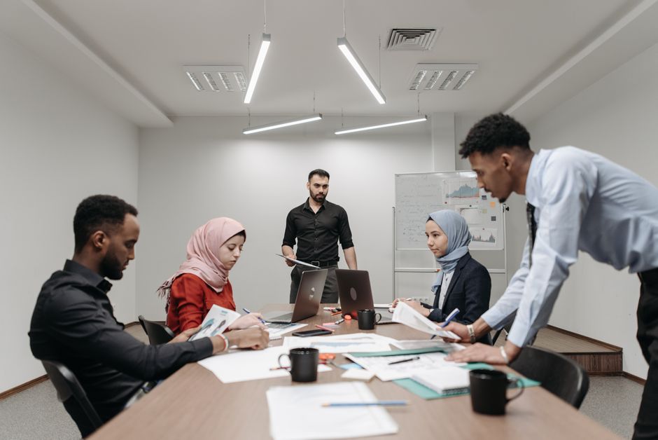 Diverse professionals engage in a strategic meeting in a modern office setting, fostering teamwork and innovation.