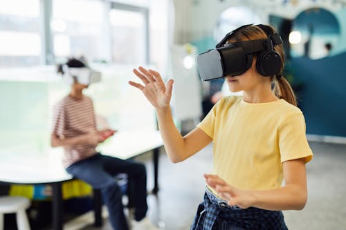Free Young female in VR glasses standing in light room and testing new device Stock Photo