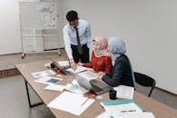 Man in Gray Dress Shirt Sitting Beside Woman in Pink Hijab