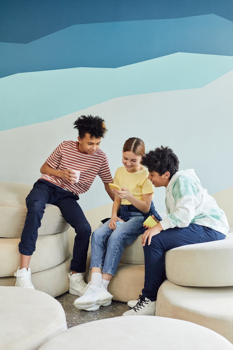 Group Of Cheerful Friends Using Smartphone