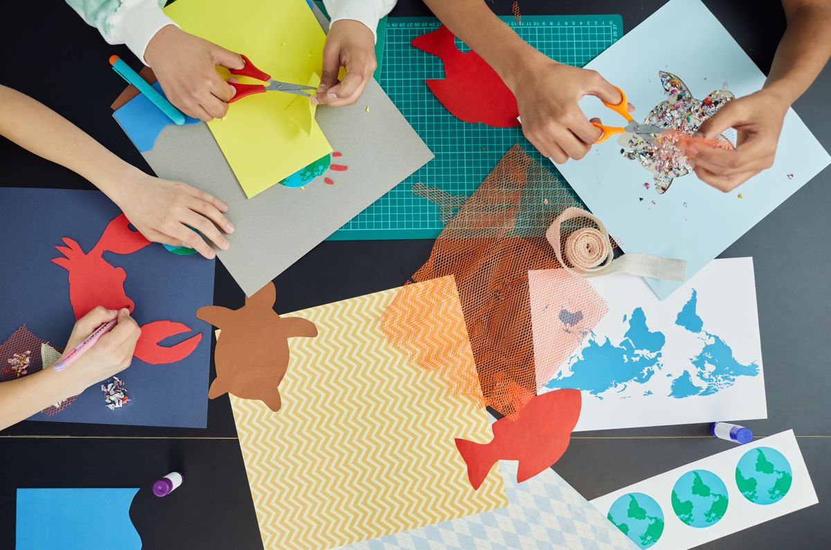 Group of children making colourful paper decorations and crafts
