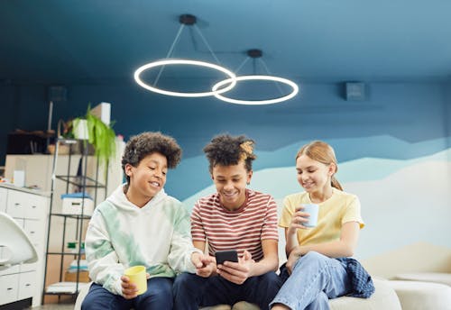 Cheerful friends having fun together with smartphone