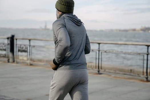 A senior man jogging by the waterfront in a city setting, promoting fitness and wellness.