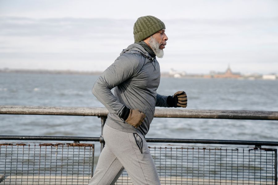 An older man running beside the water