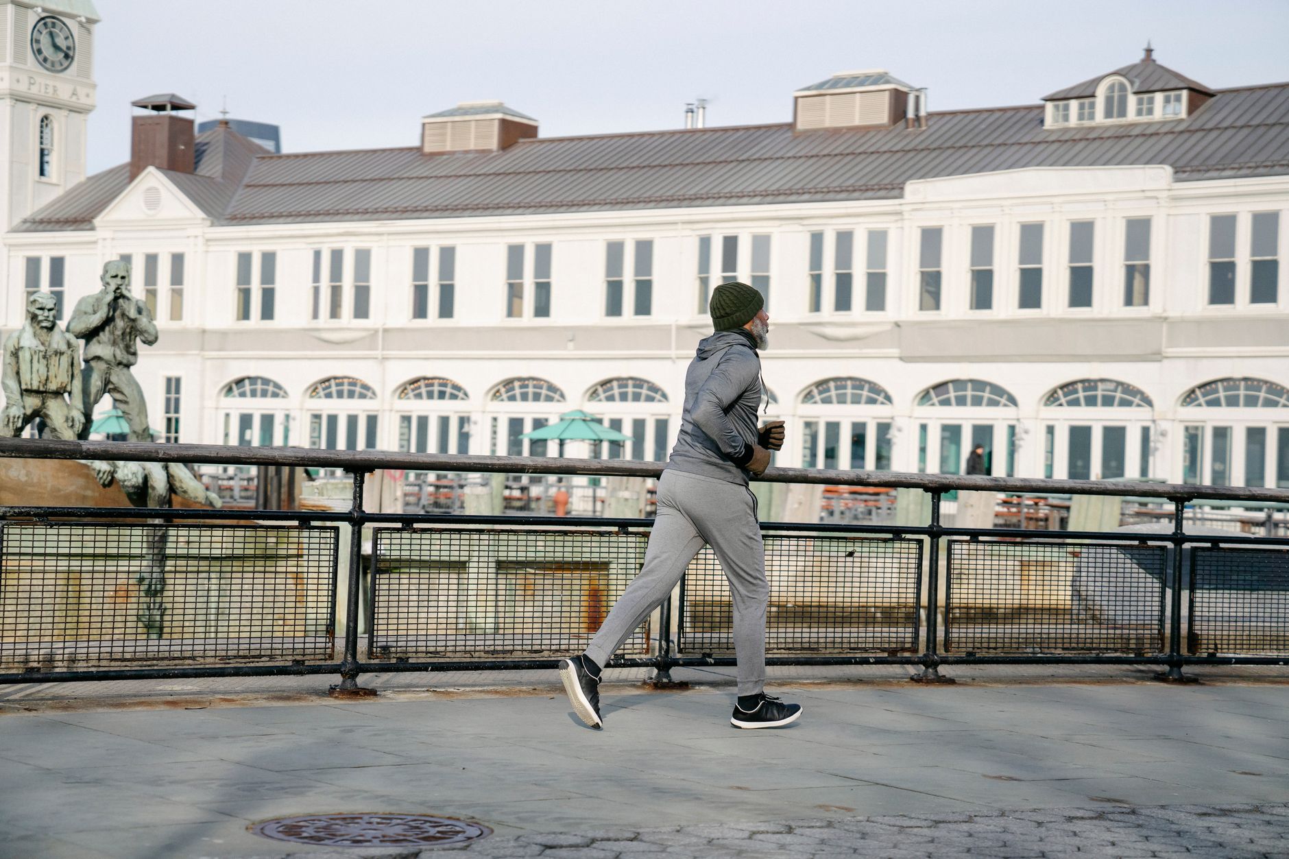 A man jogs outdoors near a historical building, promoting fitness and well-being.