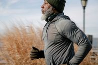 Black man in sportswear jogging in sunny autumn day